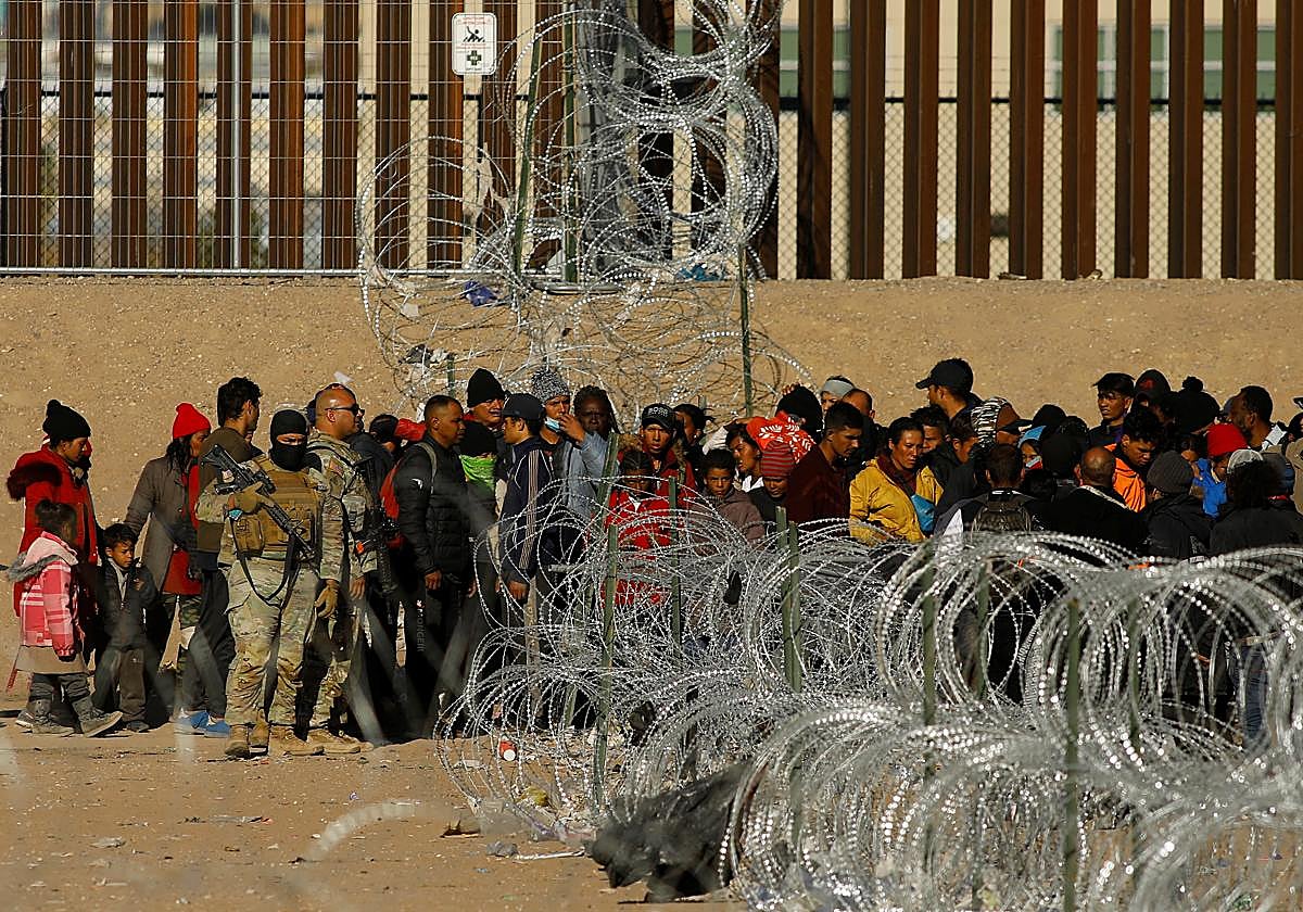 Miembros de la Guardia Nacional de Texas montan guardia al paso de inmigrantes en Ciudad Juárez, México