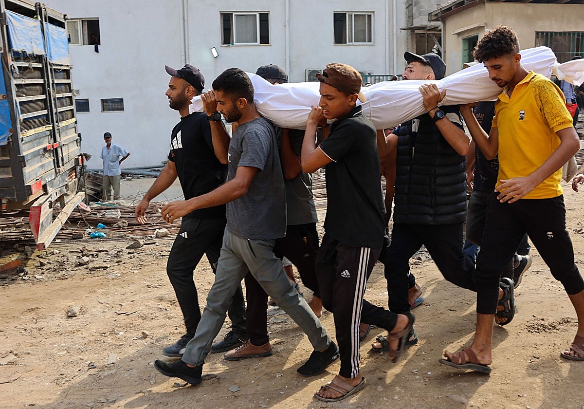Palestinos cargan el cuerpoede un familiar que murió mientras buscaba ayuda humanitaria en el norte de la Franja