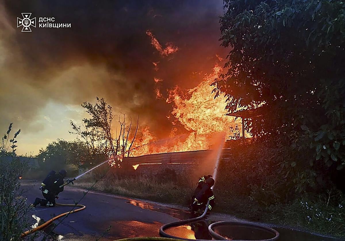 Efectivos de los servicios de emergencia ucranianos tratan de sofocar un incendio tras un ataque ruso en la zona de Kiev