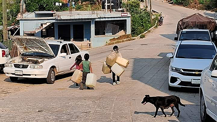 Niños acarreando bidones de agua