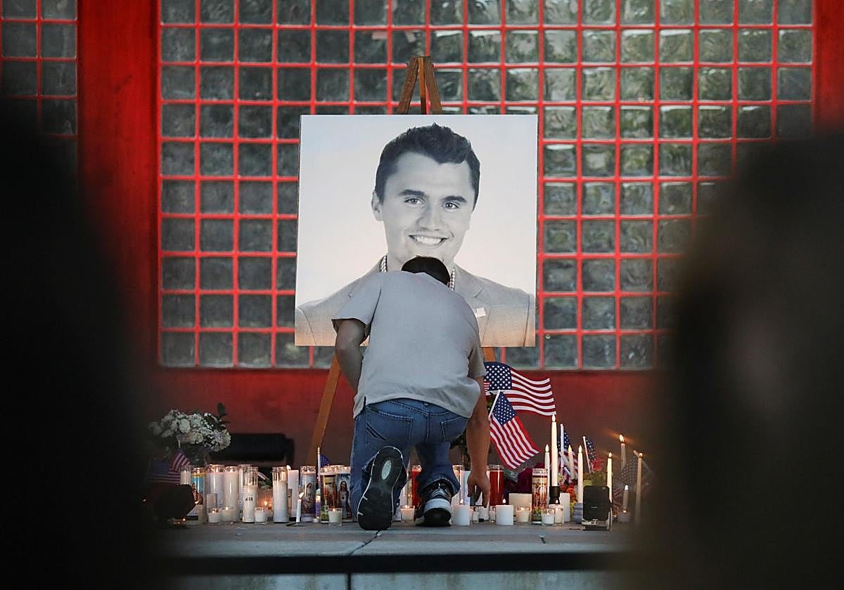 Un hombre coloca una vela durante una vigilia en el Orem City Center Park por la muerte de Charlie Kirk