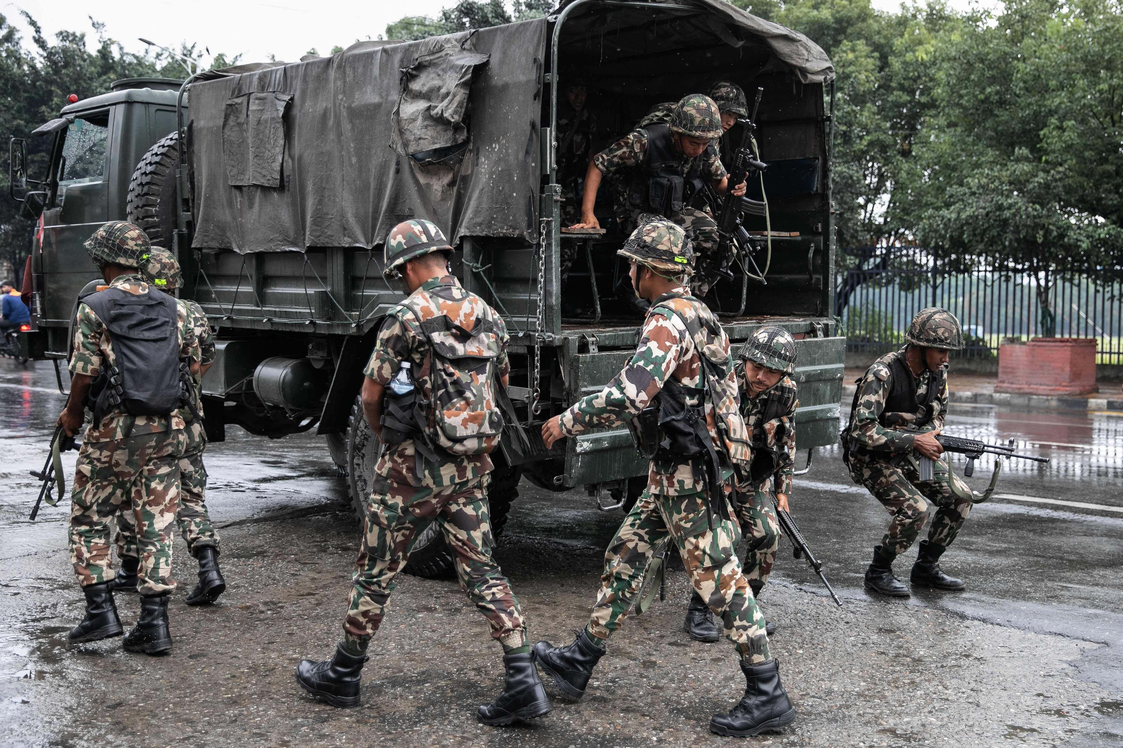 Personal del ejército llega antes de patrullar una calle durante el toque de queda impuesto para restablecer el orden público en Katmandú