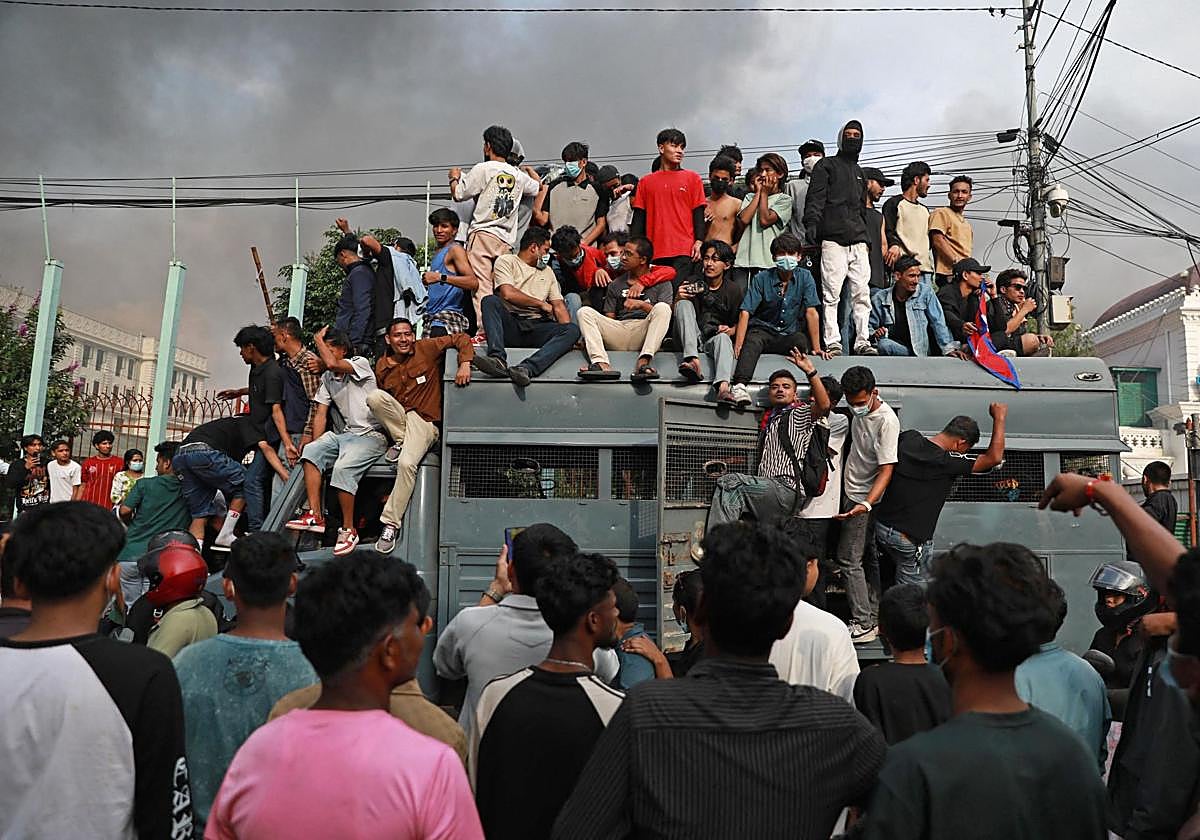 Jóvenes manifestantes toman un vehículo de seguridad frente al principal edificio administrativo del Gobierno nepalí