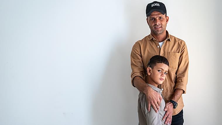 Mohammed Imad Al Shaer y su padre en la habitación donde viven ahora en Amán.