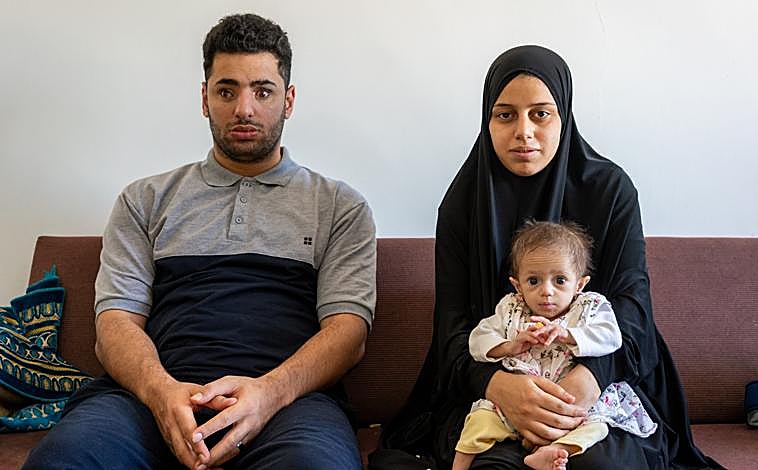 Imagen principal - Zerat solo pesa cuatro kilos. Su padre Saleh, a pesar de su ceguera, juega con su hija bajo la atenta mirada de su madre, Ziuar