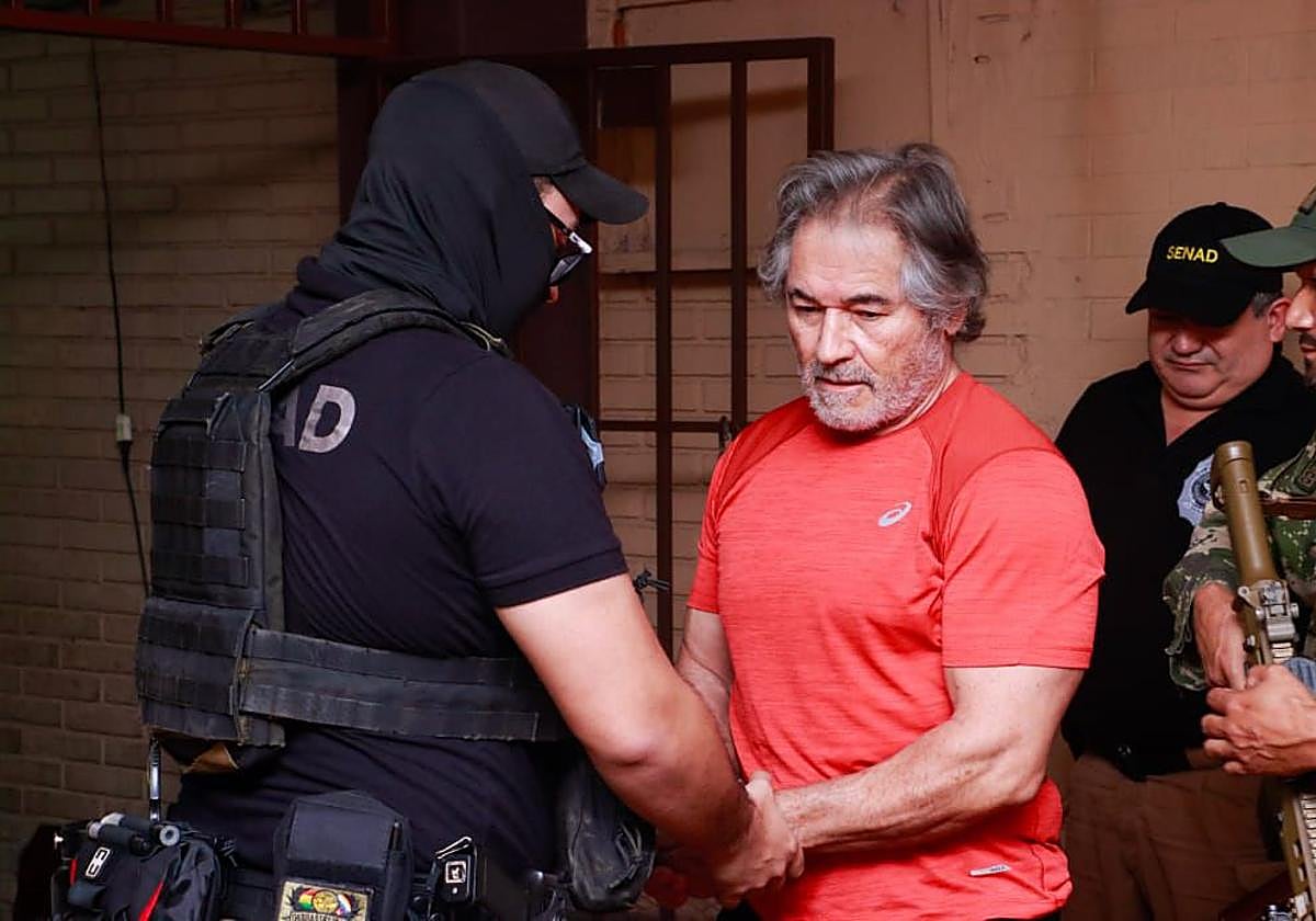 Fotografía cedida por la Secretaría Nacional Antidrogas de Paraguay que muestra el traslado del presunto líder del grupo criminal La Barredora, Hernán Bermúdez Requena