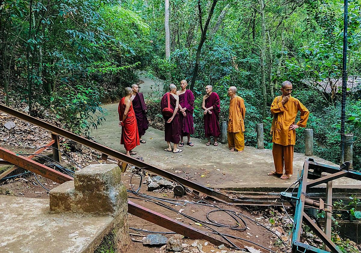 Monjes budistas observan el teléferico donde ocurrió el accidente.