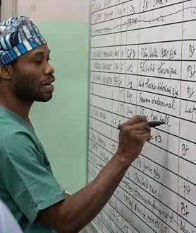 Imagen secundaria 2 - MSF atienden en quirófano a un herido en el Hospital de Rutshuru, en la primera foto. En la segunda imagen, un joven herido, por un disparo de hombres armados mientras trabajaba en los campos de Kibirizi en agosto, se recupera en el hospital. En la tercera foto, el Dr. Karry Felix (MSF) repasa la lista de operaciones del día