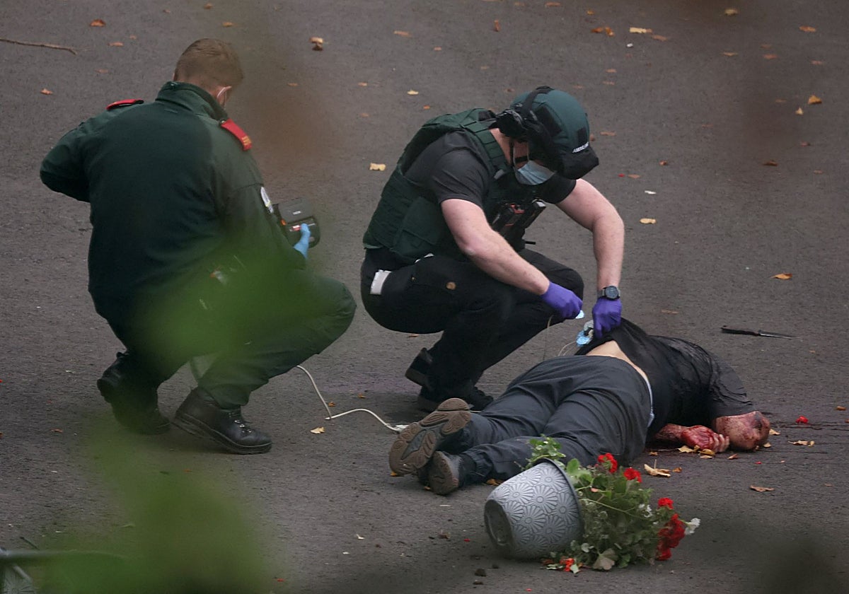Los equipos de emergencia registran el cadáver del supuesto atacante, quien se negó a rendirse ante la Policía y llevaba el cuchillo que se ve en el suelo