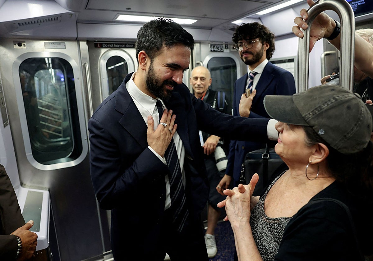 El candidato a la alcaldía charla con una mujer en el metro de Nueva York, ciudad donde se educó en colegios elitistas