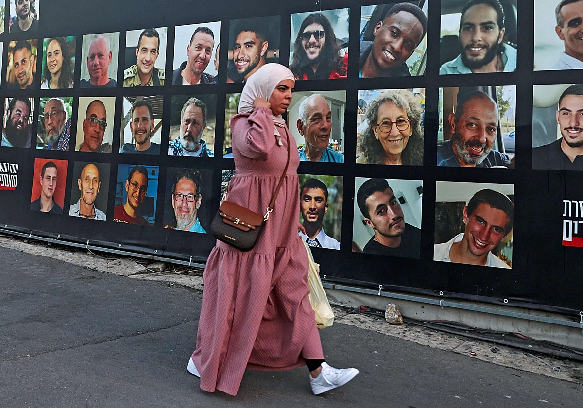Una valla muestra los retratos de los israelíes secuestrados que permanecen en la Franja, en Jerusalén