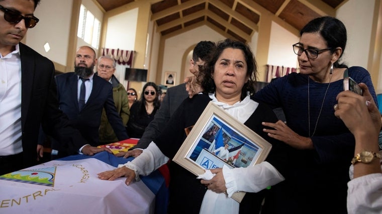 Claudia Vargas, junto al féretro de su marido, Roberto Samcam, es consolada por Zoilaméria Narváez Murillo, a la derecha, el pasado mes de junio