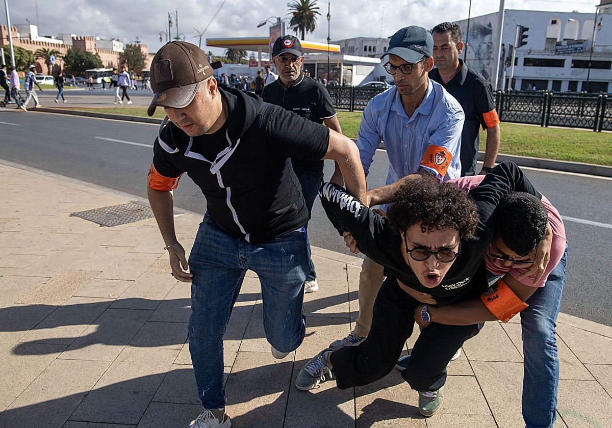 Unos agentes de seguridad marroquíes detienen a un joven que participaba en las protestas en Rabat
