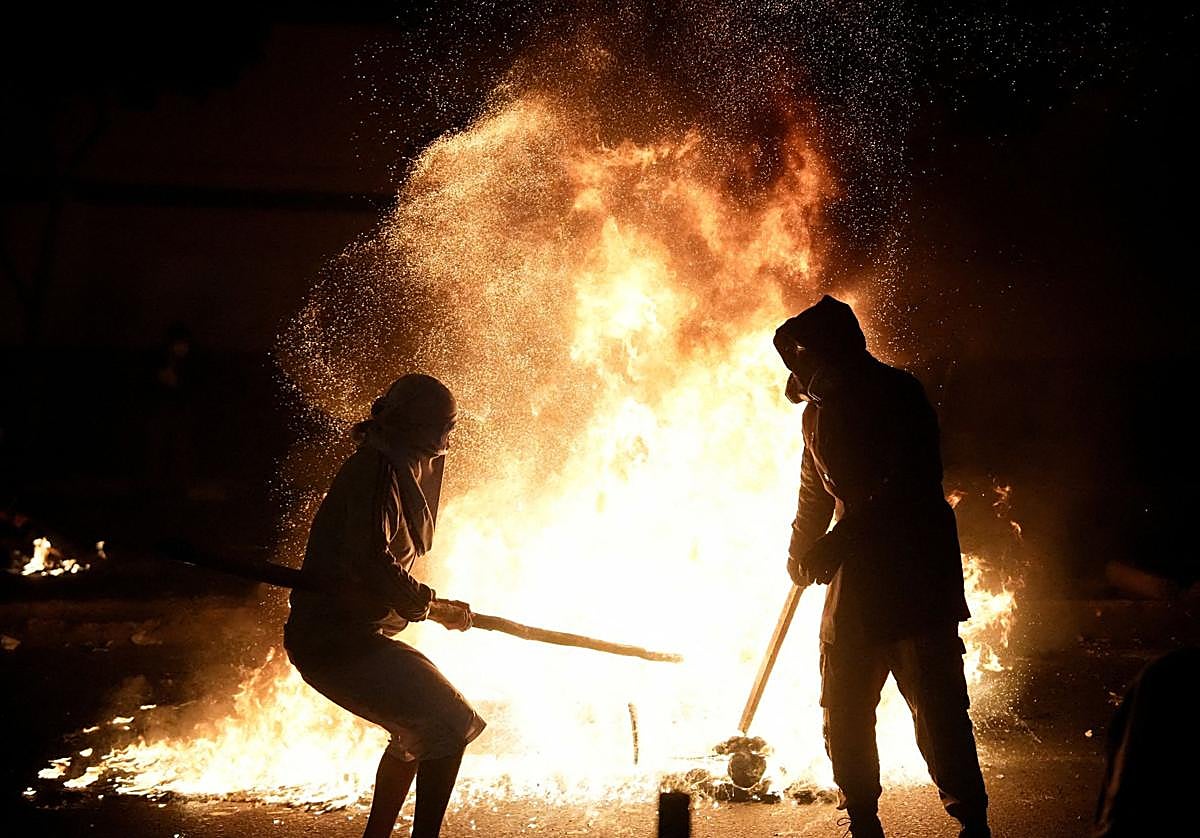 Manifestantes junto a un fuego encendido durante una protesta contra el aumento de la delincuencia, la inseguridad económica y la corrupción