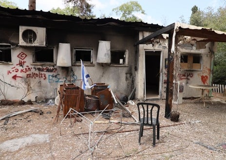 Imagen secundaria 1 - Una roca conmemorativa, dos sillones y una hamaca recuerdan el lugar donde cayó abatido Tamir Adar. Todo el kibutz de Nir Oz, asaltado por los terroristas de Hamás y los civiles de Gaza el 7 de octubre de 2023, es un mausoleo del horror, como se ve en sus casas destrozadas y en los altares hebreos por las familias asesinadas