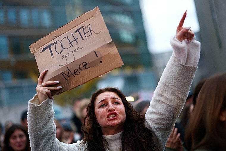 Una manifestante sostiene un cartel con el mensaje «Hijas contra Merz» durante una protesta contra el canciller alemán