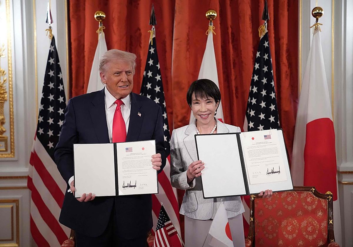 El presidente estadounidense Donald Trump (izq.) y la primera ministra japonesa Sanae Takaichi (der.) sostienen documentos firmados para un acuerdo
