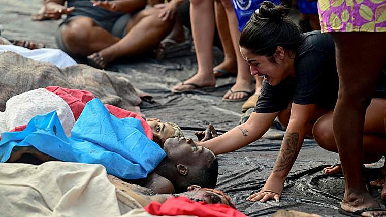 Una mujer llora junto al cadáver de un hombre que yace entre una hilera de cuerpos en la plaza São Lucas, en Río de Janeiro, tras la llamada 'Operación Contención'