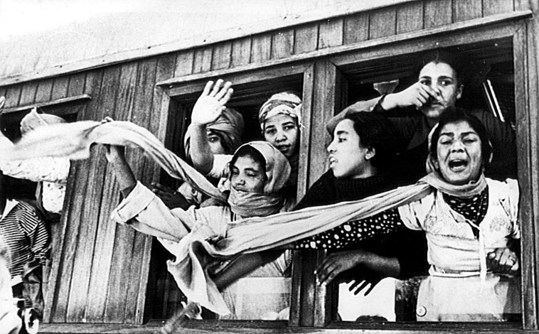 Imagen principal - Arriba, mujeres parten hacia Tarfaya, que será el punto de inicio de la Marcha Verde en 1975. Abajo, varios miembros de la marcha se sorprenden por el ensordecedor ruido de un helicóptero español que sobrevuela el recorrido de la marcha. Al lado, imagen de la Marcha