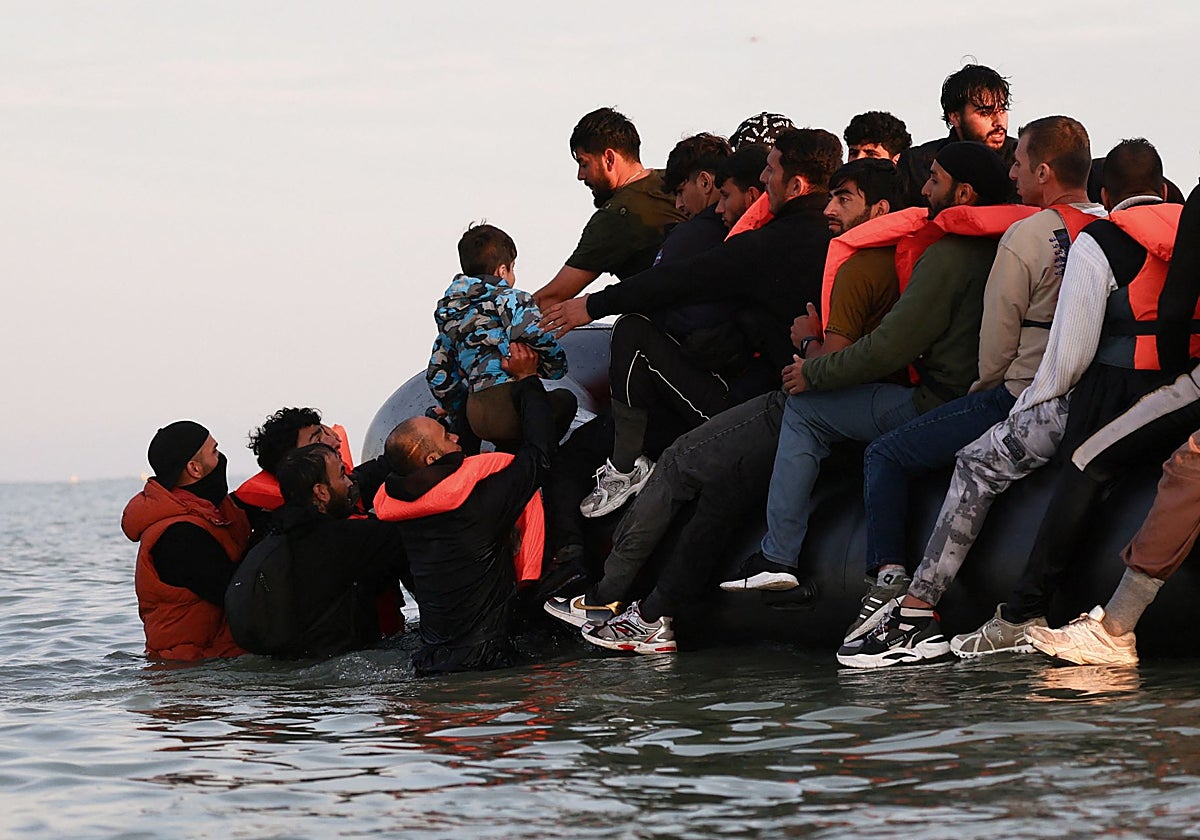Un grupo de migrantes sube a una lancha para intentar cruzar el canal de la Mancha hacia el Reino Unido