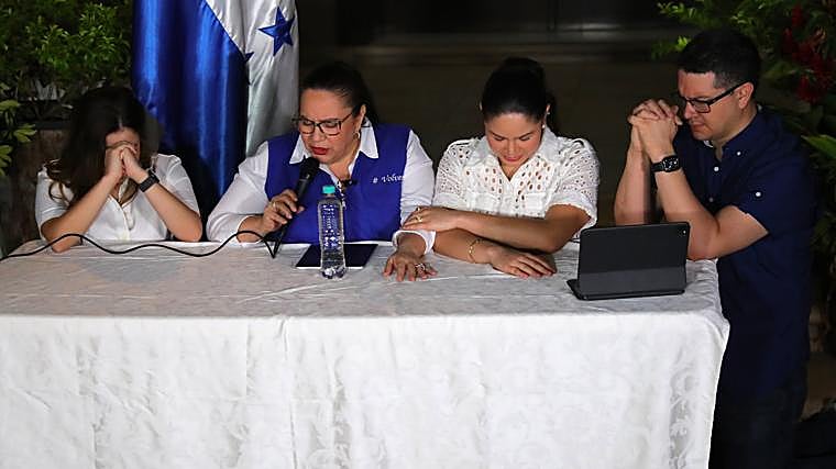 The wife of former Honduran President Juan Orlando Hernández, Ana Garcia (2-D), prays with her children Ana Daniela Hernández García (I), Isabella Hernández Garcia (2-D) and Juan Orlando Hernández García (D) during a press conference on Friday, in Tegucigalpa (Honduras)
