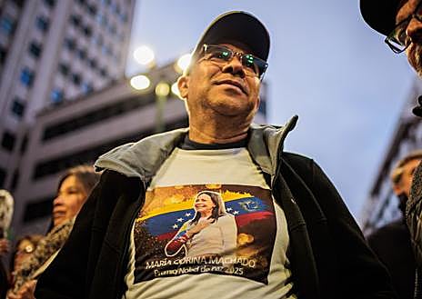 Imagem secundária 1. O ativista da oposição Leopoldo Lopez lidera uma marcha em Madrid, onde a imagem de Maria Corina Machado estava muito presente e havia muitos cartazes contra o ditador chavista. 