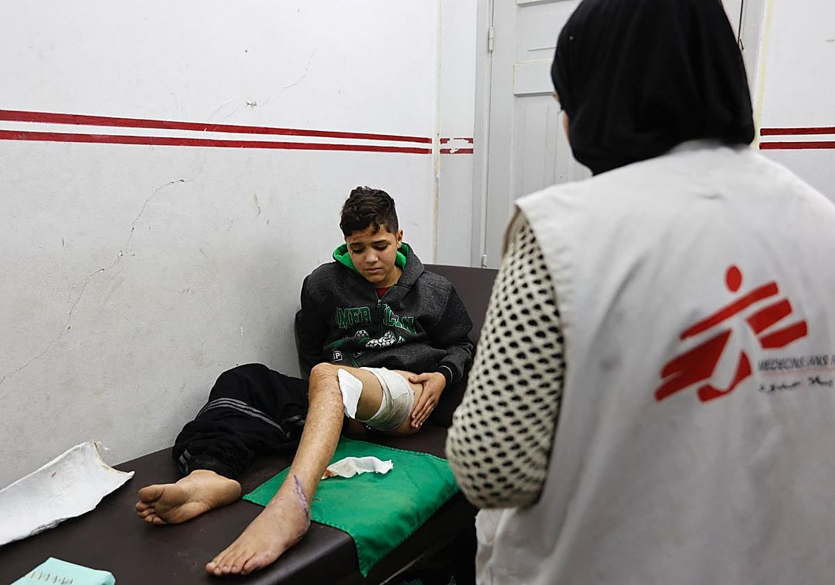 Un niño palestino herido es atendido por un miembro del personal de Médicos Sin Fronteras (MSF) en una clínica del barrio de al-Rimal de Ciudad de Gaza