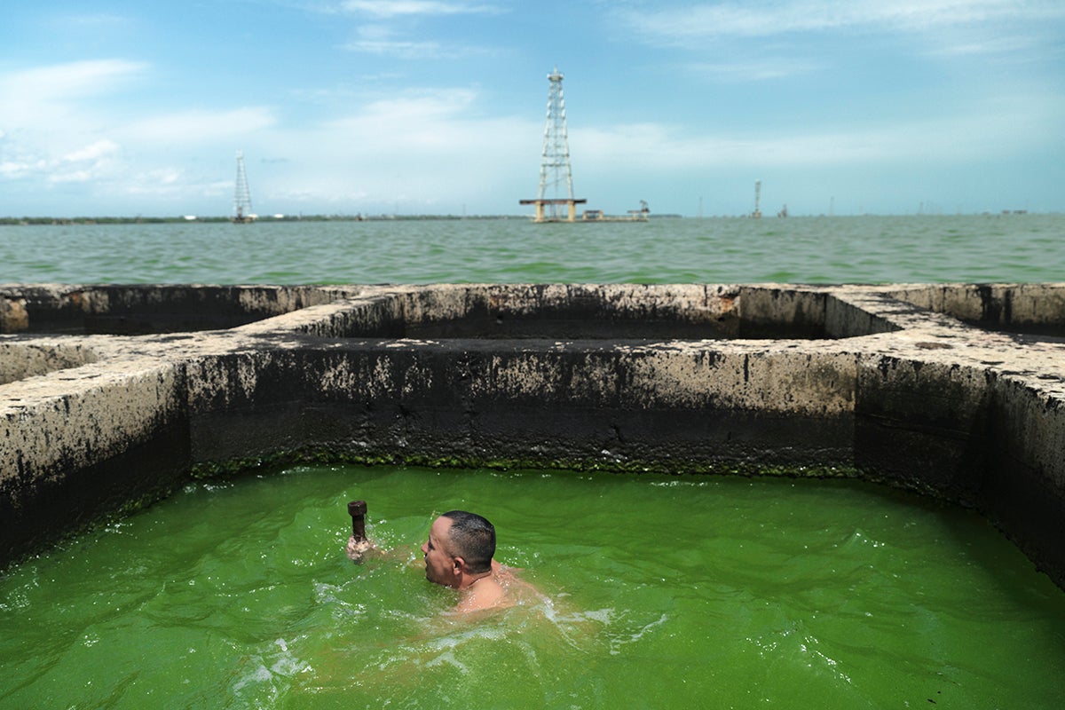 Carlos Uribarri se sumerge en el pozo de una plataforma petrolera abandonada para obligar a los peces a desplazarse hacia las redes de pesca que previamente instaló junto a la estructura petrolera