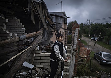 Imagen secundaria 1 - El invierno demográfico que vive Ucrania se traduce una infancia solitaria, como la de Myroslava, de siete años, quien se quedó sin baile de fin de curso por la guerra (primera imagen), o entre escombros, como la de Misha, de nueve años, en su casa de Chernihiv (segunda imagen). En Ucrania, los niños juegan en los parques bajo las ruinas de los edificios bombardeados (tercera imagen) 