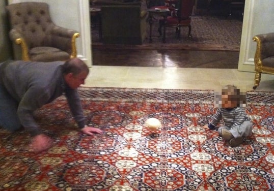El expríncipe Andrés jugando a la pelota, que reproduce un seno femenino, con un niño