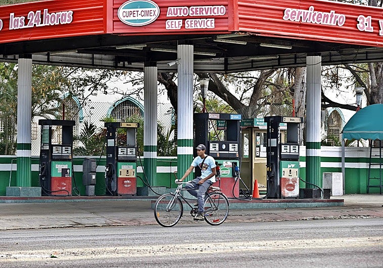 Una persona se moviliza en bicicleta frente a una estación de gasolina vacía este jueves, en La Habana
