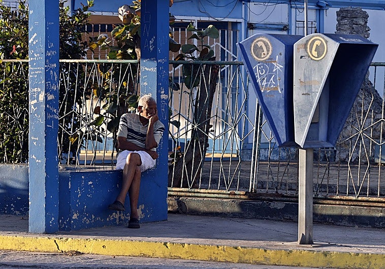 Una persona espera la llegada del transporte público en La Habana
