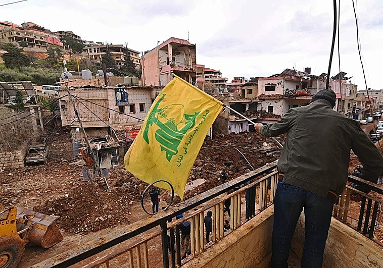 Un militante instala una bandera de Hizbolá en el balcón de un edificio de Nabi Chit, al este del Líbano.