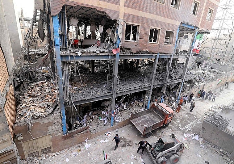 Un grupo de trabajadores limpian los escombros de un edificio bombardeado en Teherán.