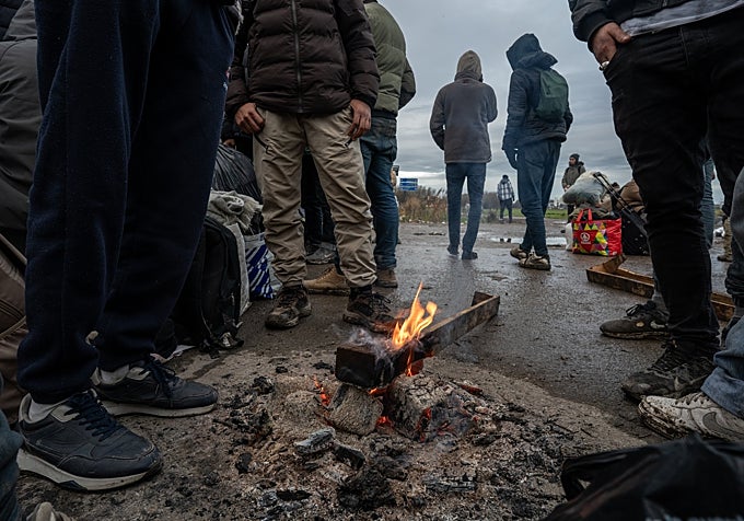 Varios migrantes esperan en Calais a que el tiempo mejore para cruzar al Reino Unido. Foto de diciembre de 2025