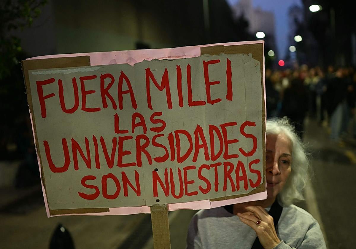 Una mujer sostiene una pancarta durante una protesta de estudiantes y trabajadores universitarios contra las políticas de Javier Milei