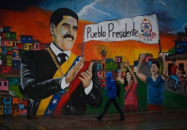 Un venezolano, frente a un mural sobre el expresidente de Venezuela, Nicolás Maduro.