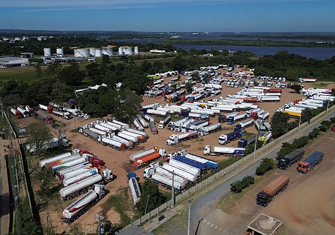 Camiones cisterna bolivianos esperan en un centro logístico de combustible a que se estabilicen las condiciones en Bolivia, en San Antonio, Paraguay.