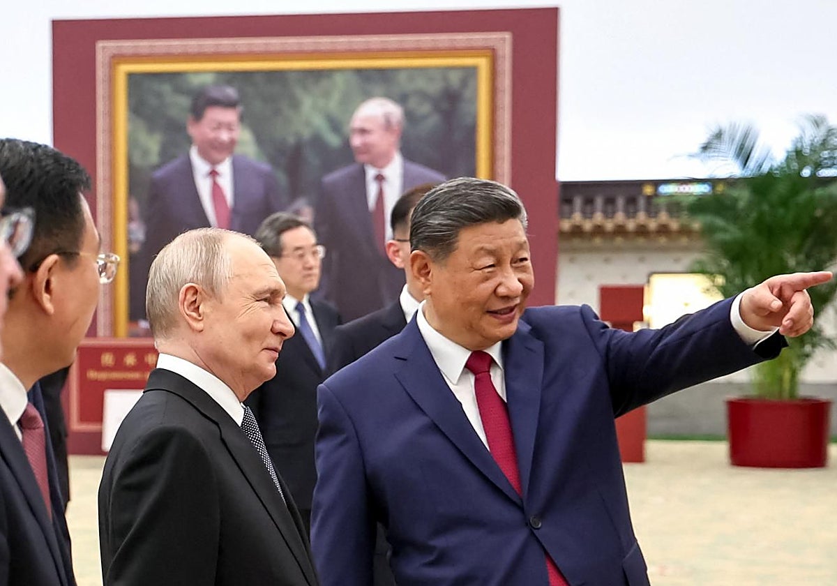 Xi enseña a Putin una exposición fotográfica durante su visita a Pekín.