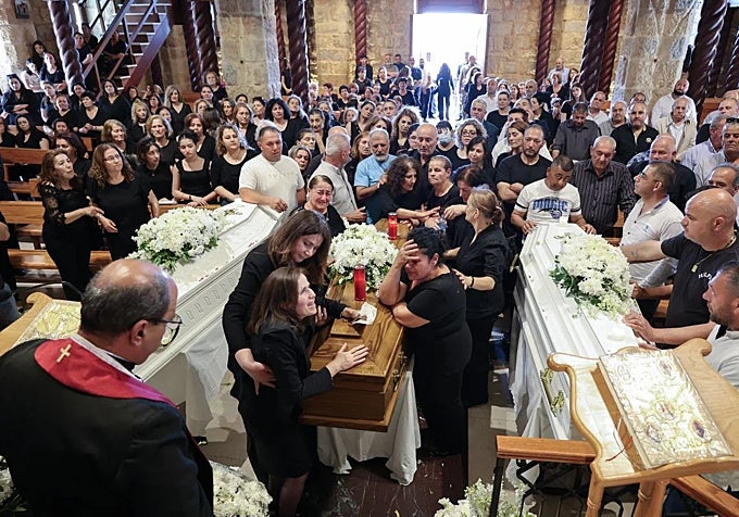 Los dolientes reunidos en el funeral del dentista James George Karam y sus hijos, Theodosia y Tony.