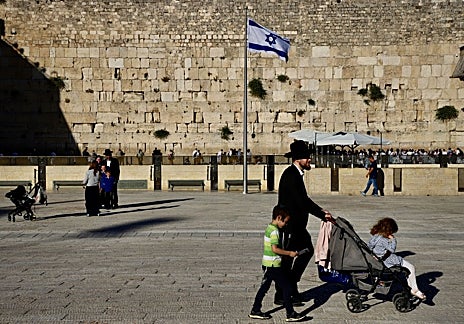 Imagen secundaria 1 - En el Muro de las Lamentaciones de Jerusalén, fieles con fusiles de asalto al hombro (primera foto) rezan junto a judíos ultraortodoxos (segunda foto y tercera foto), bajo fuertes medidas de seguridad para impedir atentados islamistas.  