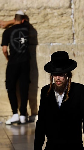 Imagen secundaria 2 - En el Muro de las Lamentaciones de Jerusalén, fieles con fusiles de asalto al hombro (primera foto) rezan junto a judíos ultraortodoxos (segunda foto y tercera foto), bajo fuertes medidas de seguridad para impedir atentados islamistas.  