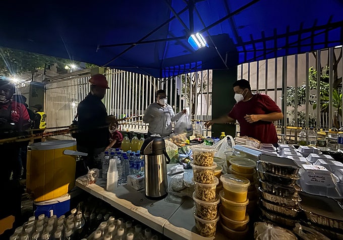 Varias personas preparan comidas para los voluntarios en San Bernardino