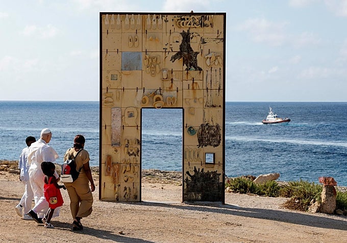 León XIV, con una familia de inmigrantes, se encamina a la Puerta de Europa, el monumento que recuerda a los ahogados en los naufragios de pateras.