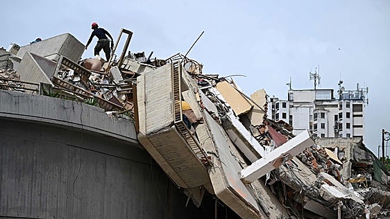 Un rescatista busca v&iacute;ctimas entre los escombros en Macuto, en el estado de Vargas.