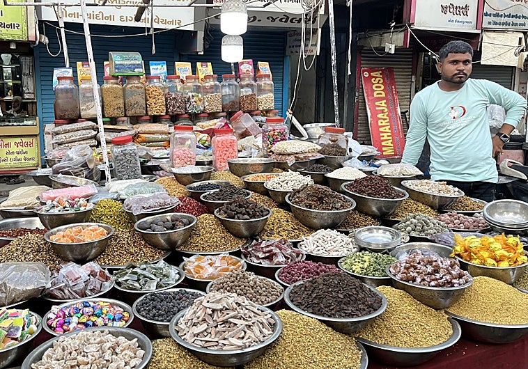 Imagen principal - Un puesto de especias en un mercadillo de Ahmedabad (Guyarat), en la primera foto. En la segunda imagen, una fachada en el barrio musulmán de la vieja Delhi. Una niña pasea en una calle perpendicular a una de las arterias principales de Nueva Delhi.