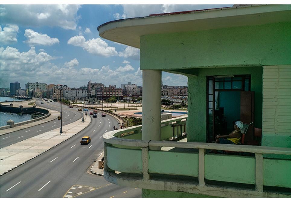 Una mujer descansa en la terraza de su casa situada en La Habana vieja.