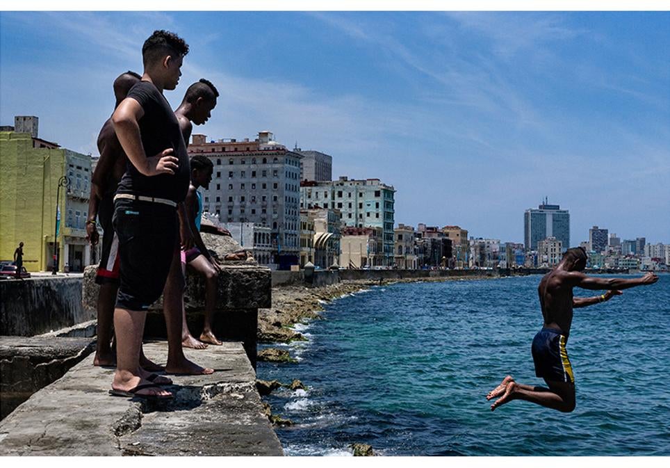 Un grupo de adolescentes se baña en el mar junto al malecón de La Habana.