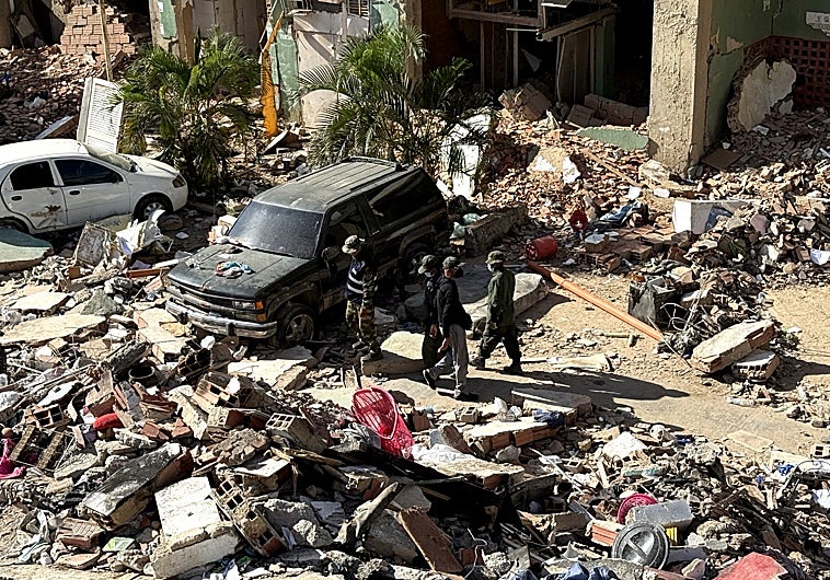 Imagen principal - Efectivos militares recorren los escombros del complejo residencial OPPPE en Tanaguarena (La Guaira) sin herramientas de rescate, mientras los voluntarios civiles trabajan con palas y máscaras sobre las losas colapsadas de los edificios de Misión Vivienda. Geraldine Coromoto Rivero muestra en su teléfono la imagen de su hijo de dos años y del padre del niño, ambos atrapados bajo los escombros de la OPP-33, en la misma localidad.
