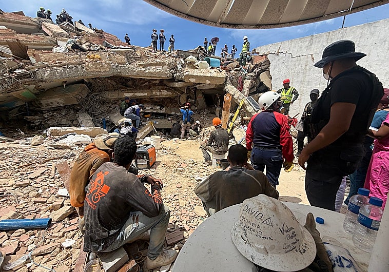 Imagen principal - Voluntarios trabajan bajo sombrillas improvisadas sobre los escombros, junto con los efectivos de la FANB y Protección Civil en la OPP-33, en Tanaguarena. Augusto Rafael Segovia, exbombero venezolano emigrado a Colombia, regresó por sus propios medios para trabajar como voluntario en la zona de catástrofe.